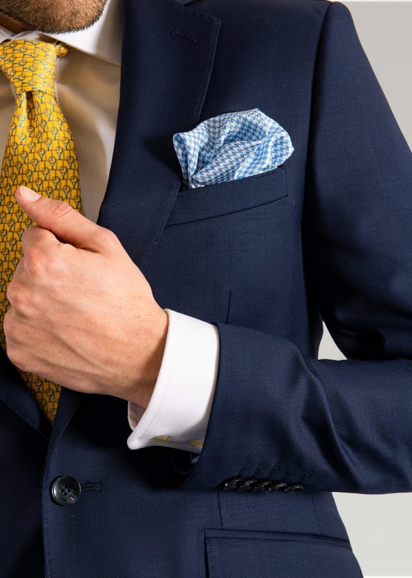 Men's navy suit styled with pale blue silk pocket square