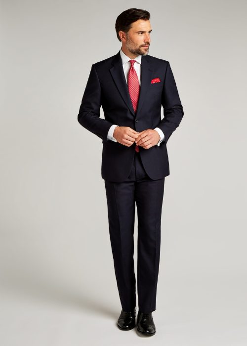 Classic fit navy pic and pic suit styled with white shirt and red tie