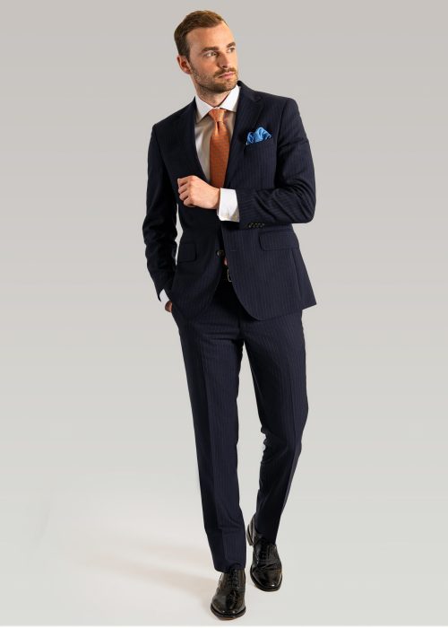 Men's navy stripe suit styled with white shirt and orange tie