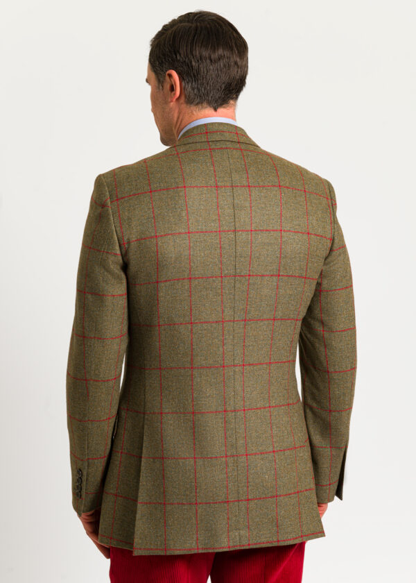 The back of a men's tan tweed jacket with red windowpane check. Beautifully tailored jacket worn with red moleskin trousers.