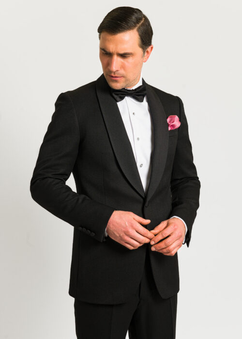 A black shawl collar dinner suit styled with white dress shirt, bow tie and pink pocket square.