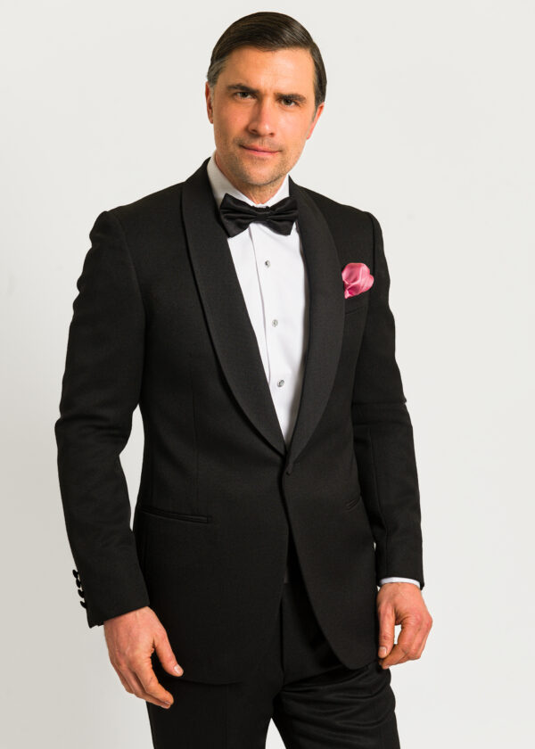 A stunning traditional dinner suit in black with shawl collar, white dress shirt, bow tie and pink pocket square.