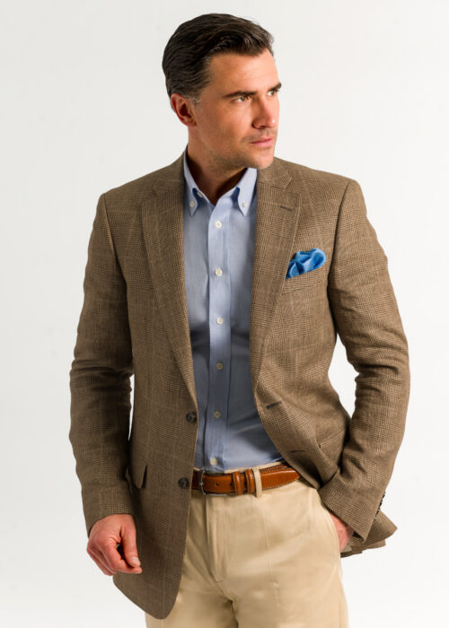 A tailored tan check men's linen jacket, worn with chino and pale blue shirt.