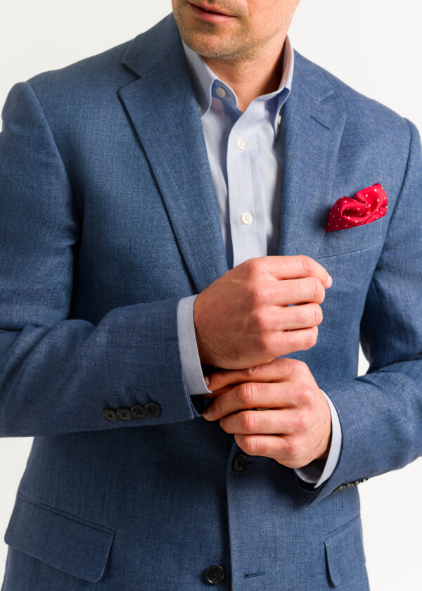 Royal blue men's smart linen jacket styled with open neck shirt and red pocket square.