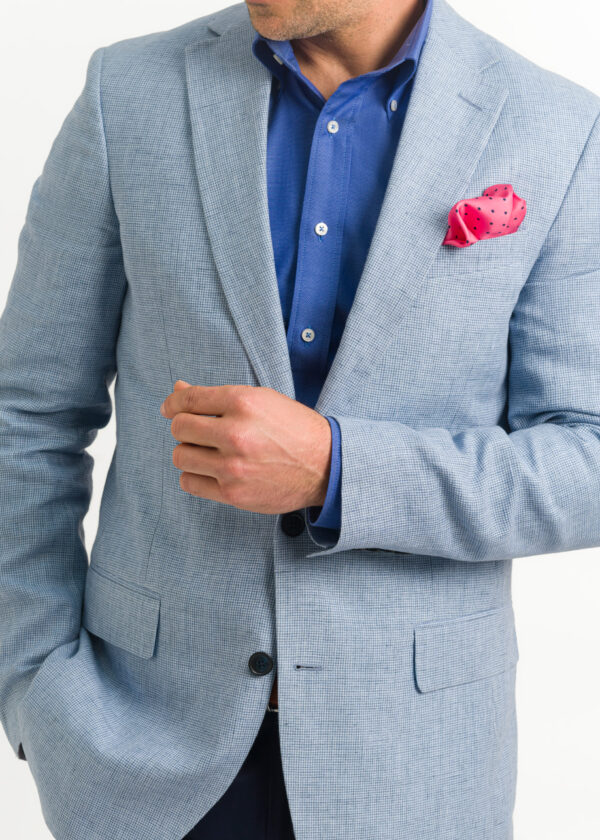 A sky blue men's linen jacket with open neck blue shirt and fun red pocket square.