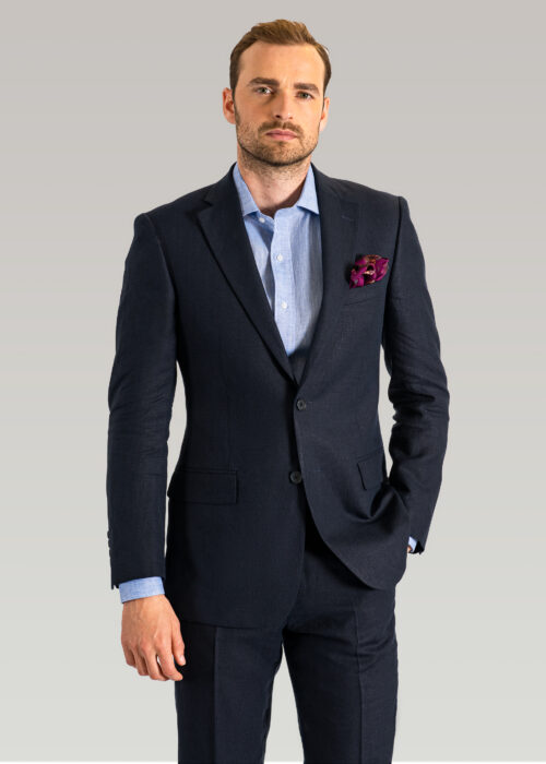 A men's navy line suit with open neck blue shirt.