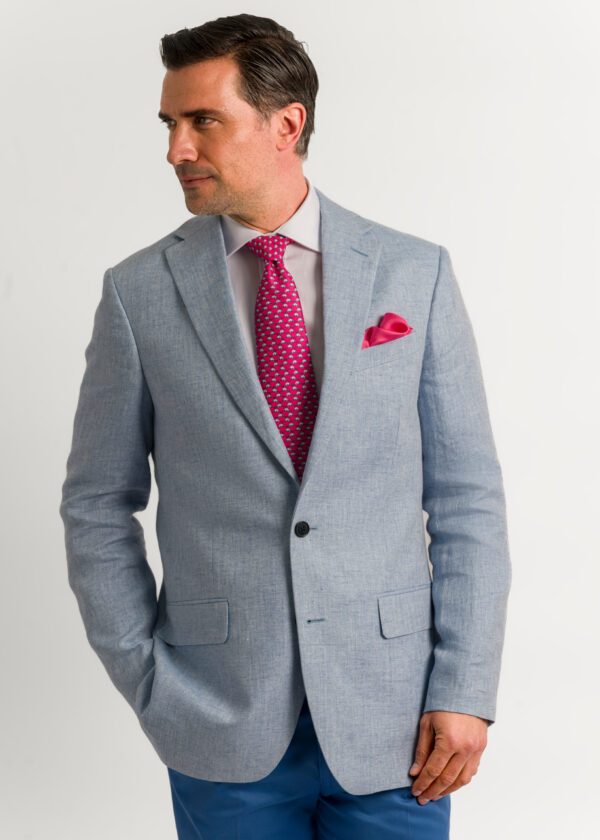 A men's blue linen jacket styled with red tie and silk pocket square.