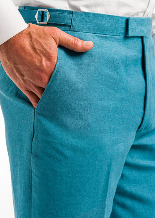 The pocket detail of men's smart teal linen trousers.