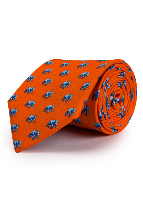 A rolled up Roderick Charles orange silk tie with elephants